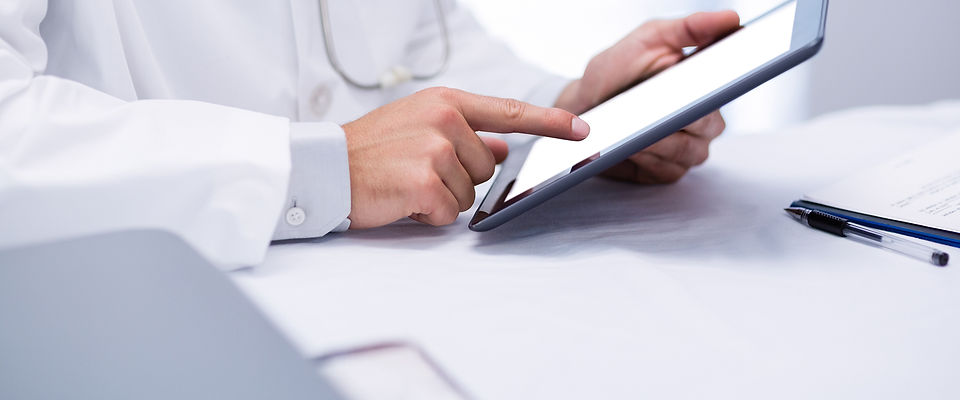 Doctor holding and pointing at a tablet during consultation booking